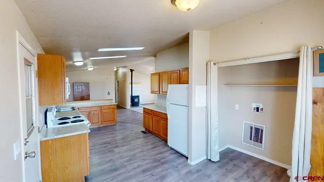 a large white kitchen with wooden floor