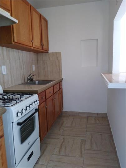 8910 Collins Avenue, Unit 1 Surfside, FL 33154 - Photo 2 of 16 a kitchen with a stove and a sink