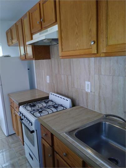 8910 Collins Avenue, Unit 1 Surfside, FL 33154 - Photo 4 of 16 a kitchen with a sink and cabinets