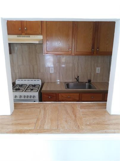 8910 Collins Avenue, Unit 1 Surfside, FL 33154 - Photo 5 of 16 a view of kitchen with wooden cabinet