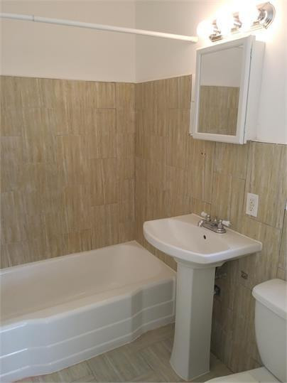 8910 Collins Avenue, Unit 1 Surfside, FL 33154 - Photo 7 of 16 a bathroom with a sink a toilet and shower