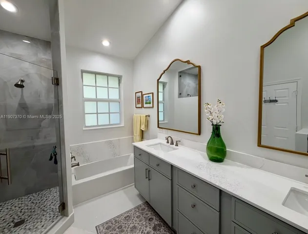 a spacious bathroom with a double vanity sink mirror and shower