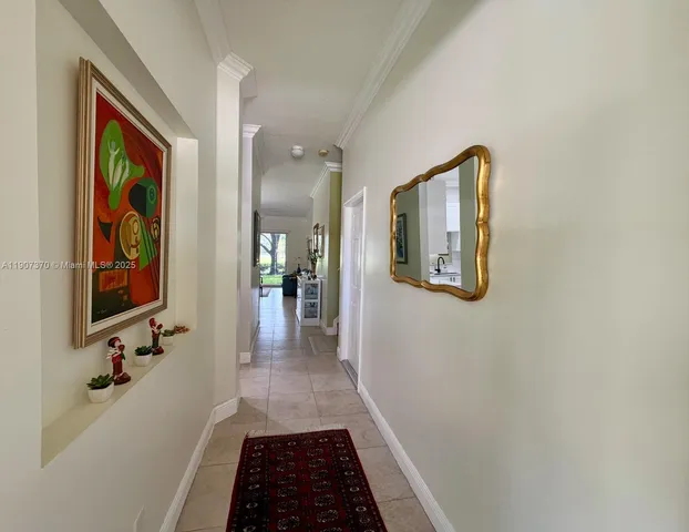 a hallway with painting on the wall and a mirror