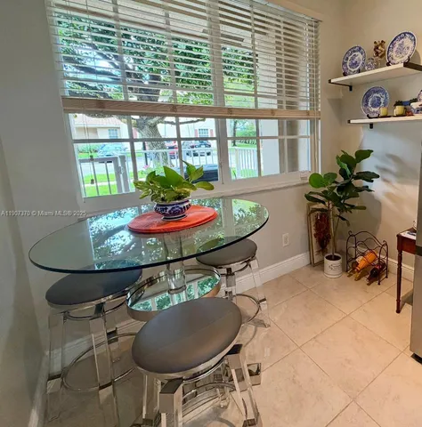 a dining room with furniture and a floor to ceiling window