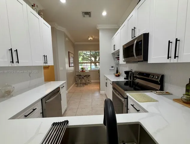 a kitchen with stainless steel appliances a stove sink microwave and cabinets