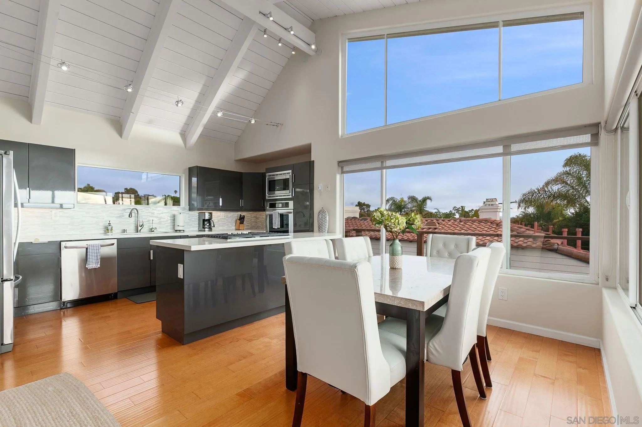 5620 La Jolla Boulevard La Jolla, CA 92037 - Photo 19 of 50 a dining room with stainless steel appliances kitchen island granite countertop a table chairs and a view of living room