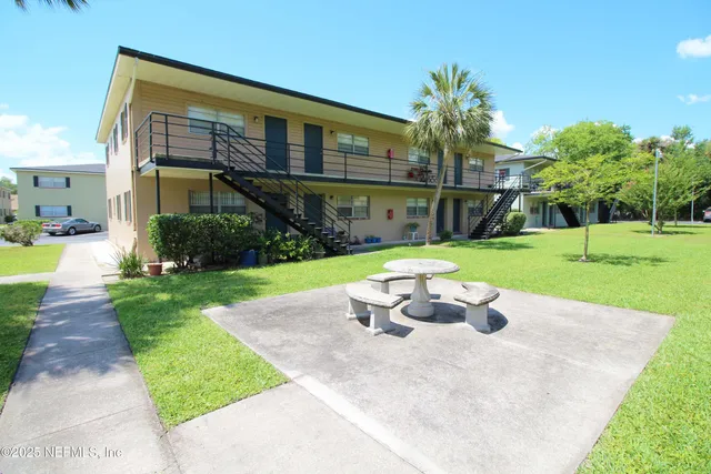 a view of a chair and table in backyard of the house