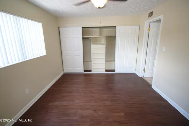 an empty room with windows and closet
