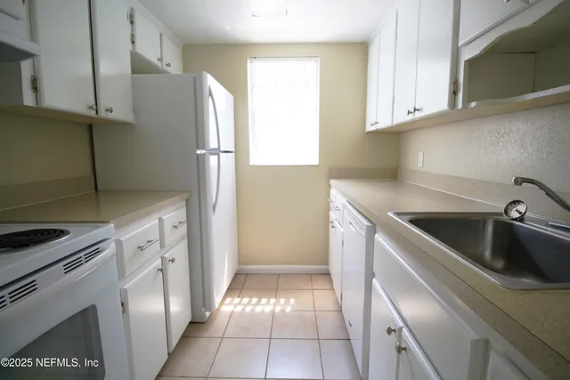 a kitchen with a refrigerator and a sink