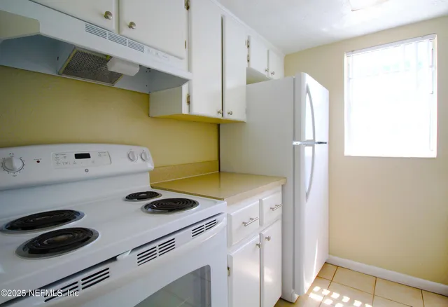a kitchen with a refrigerator and a stove