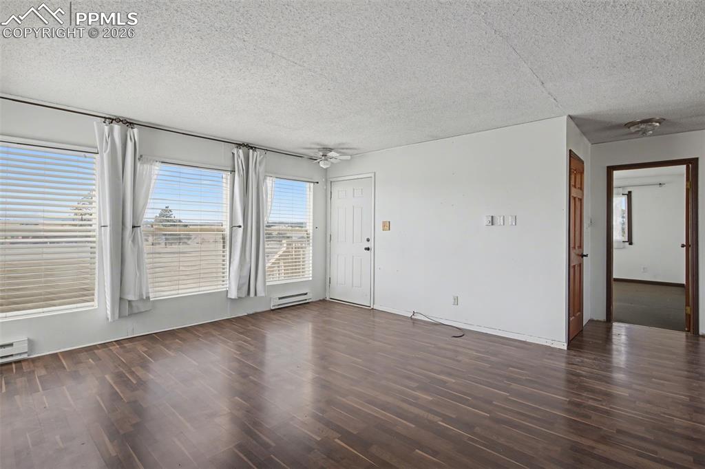 12380 Old Barn Road Elbert, CO 80106 - Photo 13 of 42 a view of an empty room with wooden floor and a window