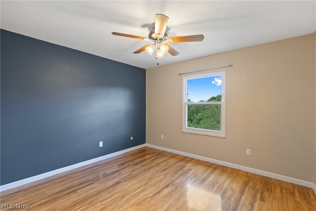 54131 Key Bellaire Road Bellaire, OH 43906 - Photo 26 of 36 Empty room with ceiling fan and light wood-type flooring