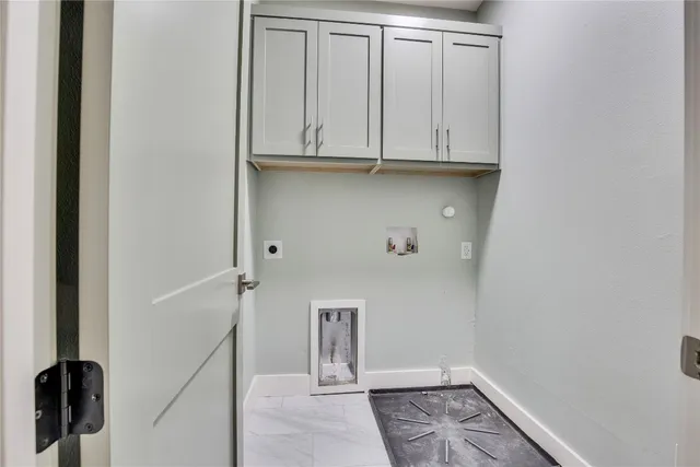 a view of cabinets and utility room with closet