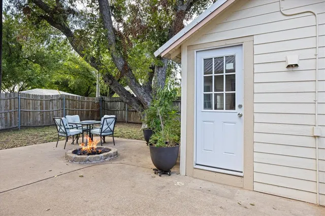 a view of backyard with table and chairs and a large tree