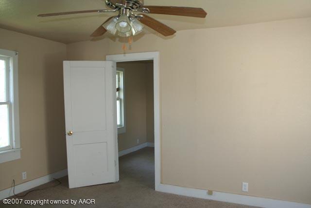 4331 South Polk Street Amarillo, TX 79110 - Photo 4 of 9 an empty room with a ceiling fan and a window