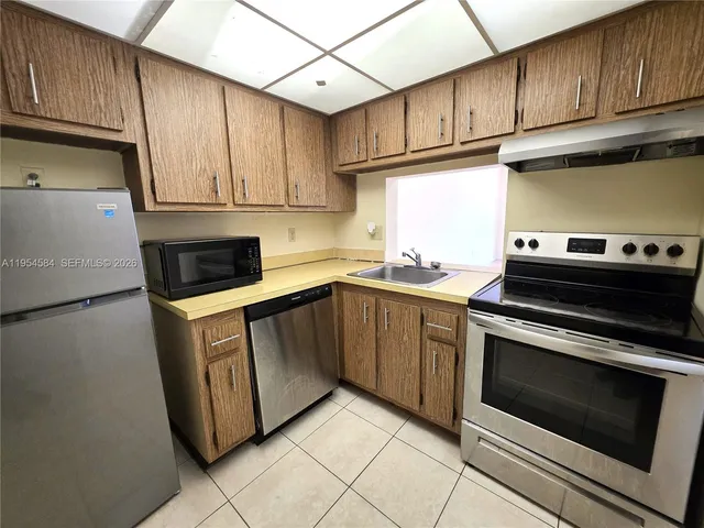 a kitchen with granite countertop cabinets stainless steel appliances and a sink