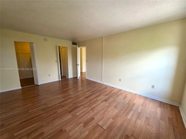 an empty room with wooden floor and closet