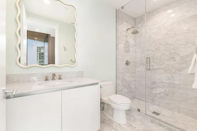 a bathroom with a toilet a sink and a mirror