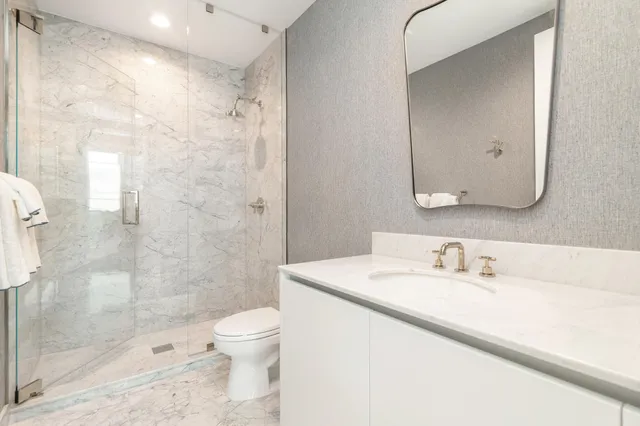 a bathroom with a sink a toilet and shower