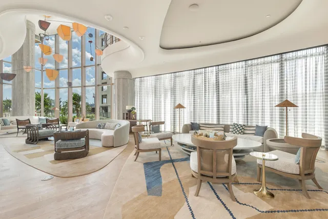 a living room with furniture a large window and wooden floor