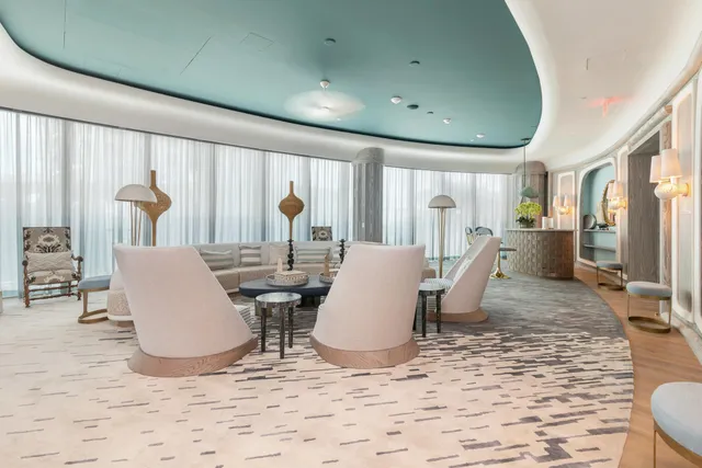 a view of a dining hall with lots of furniture and windows