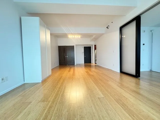 a view of empty room with wooden floor