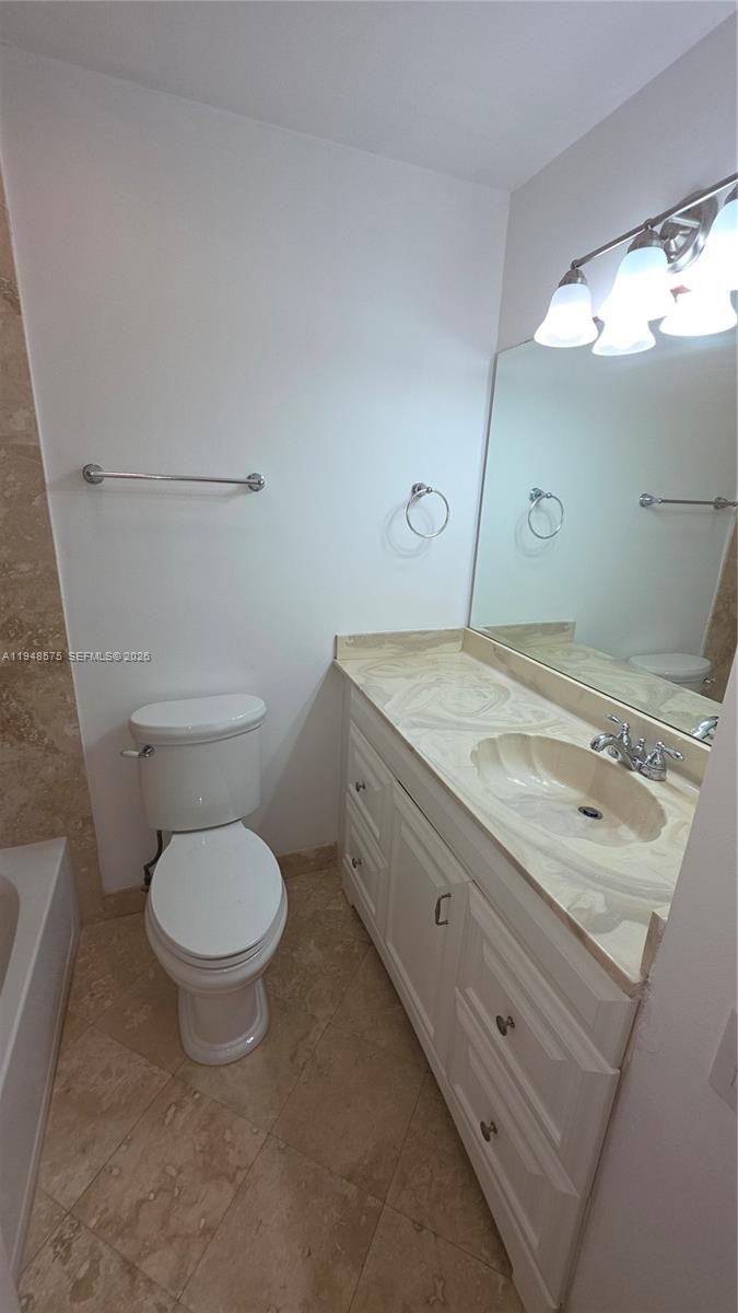 7124 Southwest 114th Place, Unit A Miami, FL 33173 - Photo 11 of 19 a bathroom with a granite countertop toilet sink and mirror