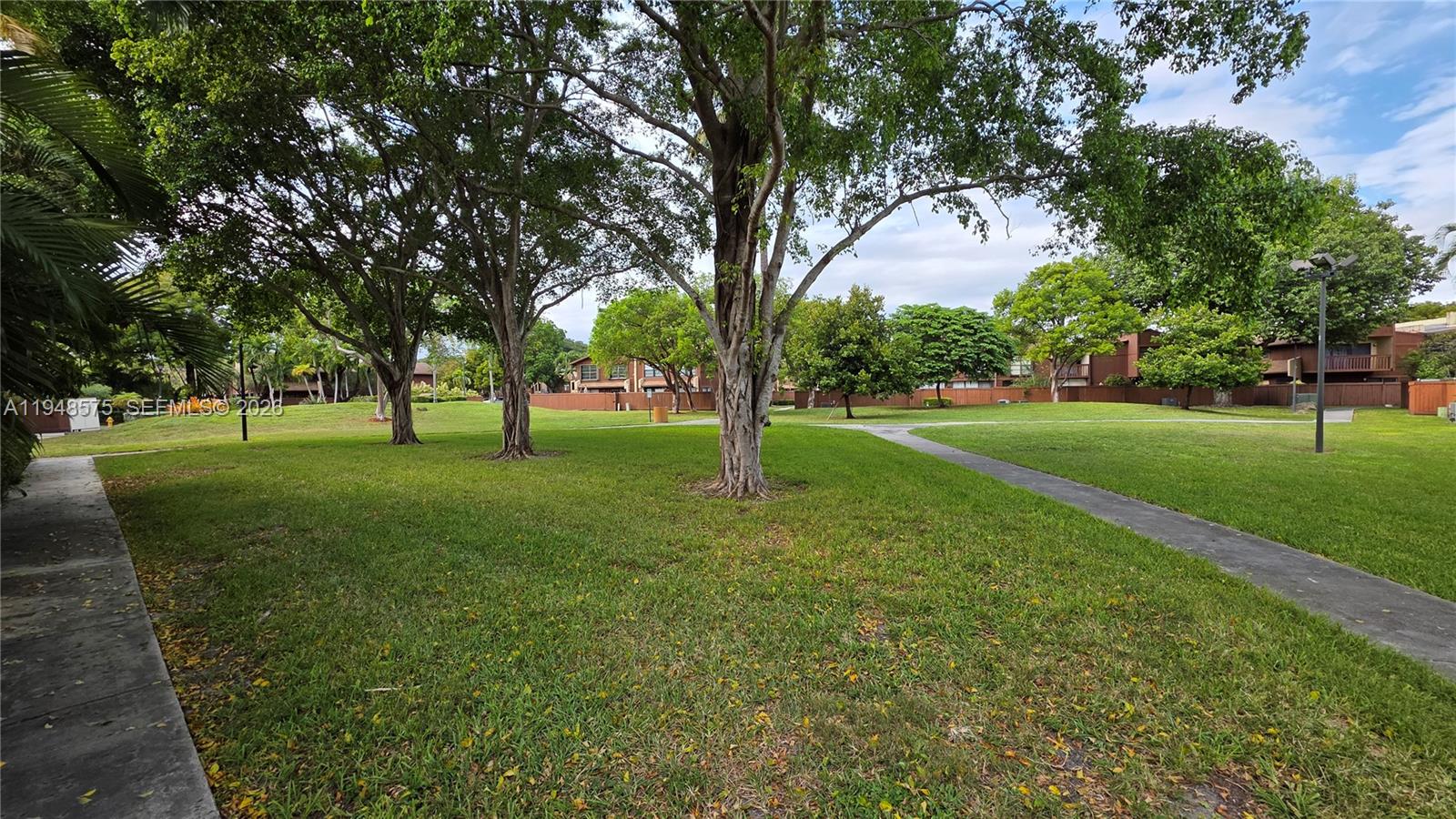 7124 Southwest 114th Place, Unit A Miami, FL 33173 - Photo 19 of 19 a view of grassy field with benches and trees all around