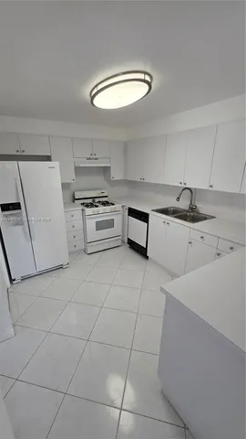 a kitchen with granite countertop a sink and a stove top oven