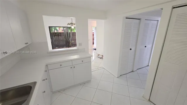 a view of a kitchen with white cabinets