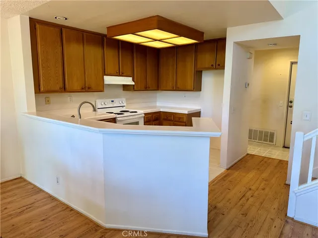 a kitchen with a sink cabinets and wooden floor