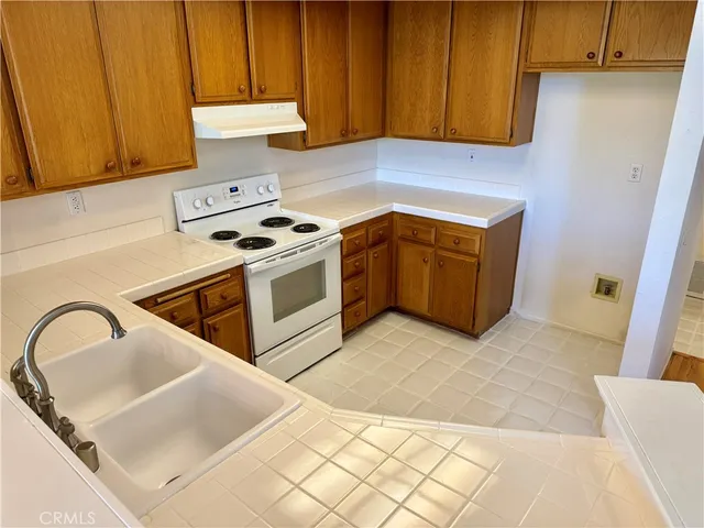 a kitchen with a sink a stove and cabinets