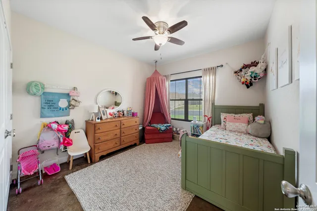 a bedroom with a baby bed a chandelier and a window