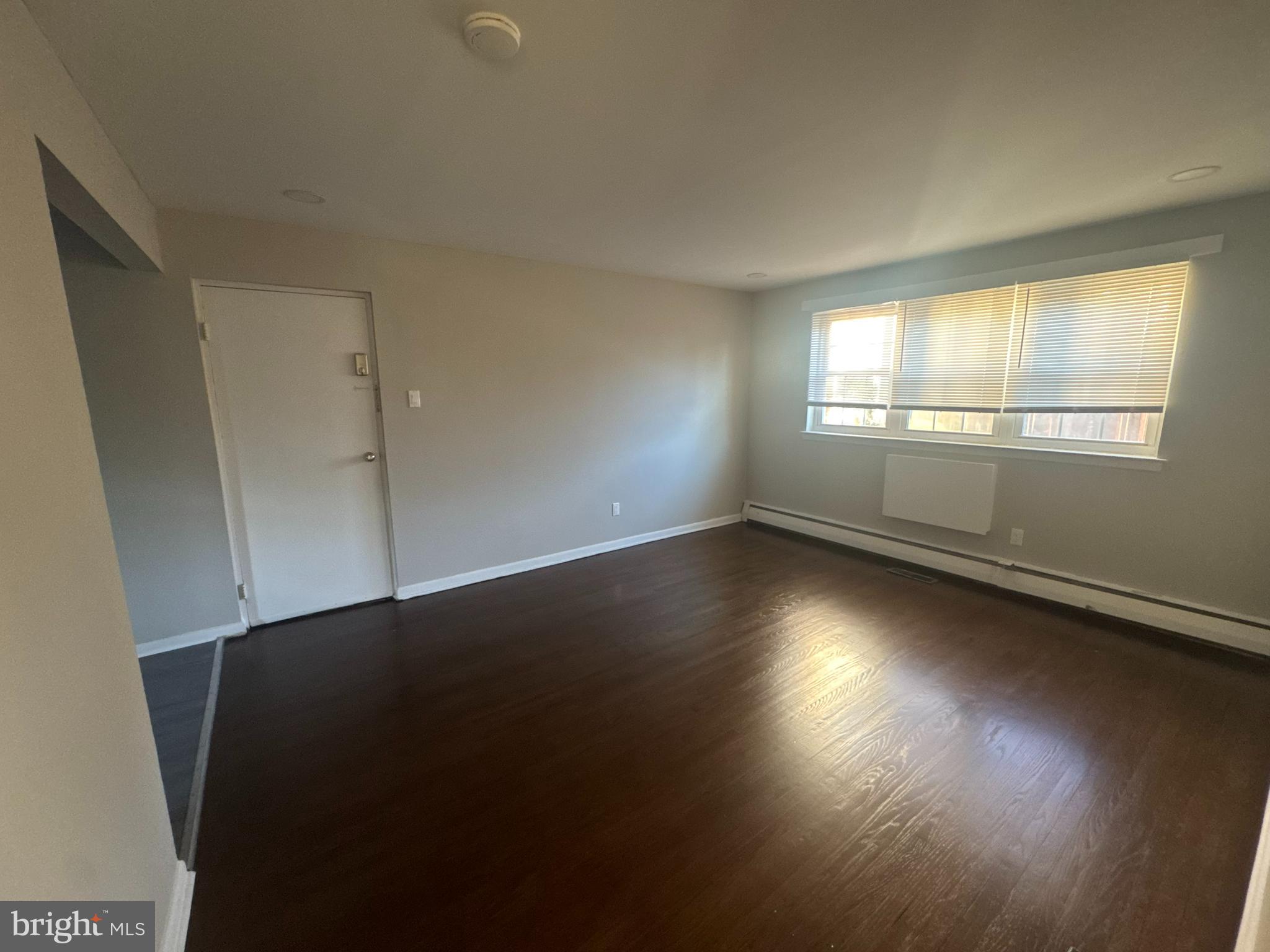 210 Trinity Avenue, Unit A1 Ambler, PA 19002 - Photo 5 of 8 an empty room with wooden floor and windows