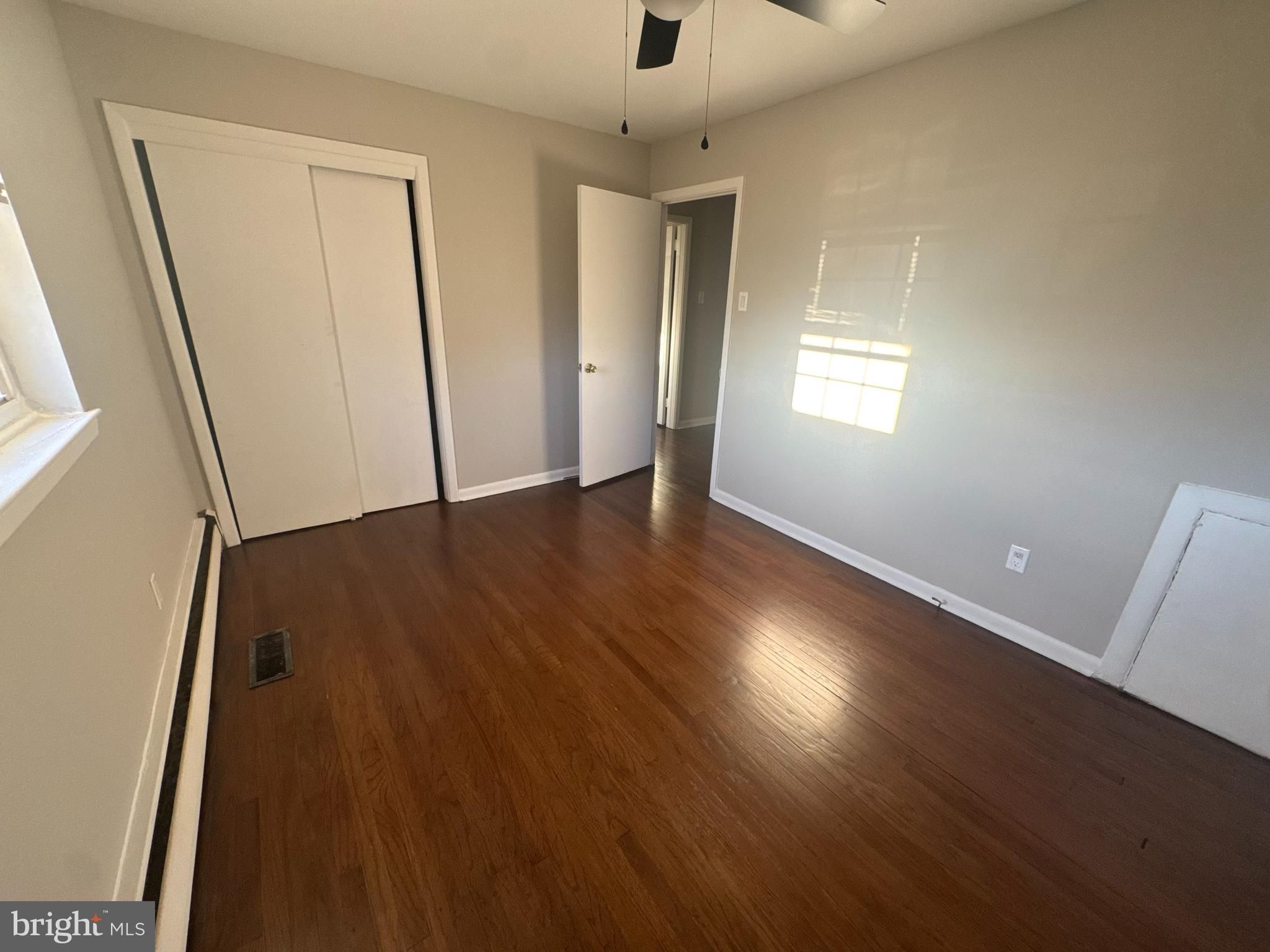 210 Trinity Avenue, Unit A1 Ambler, PA 19002 - Photo 6 of 8 an empty room with wooden floor and windows