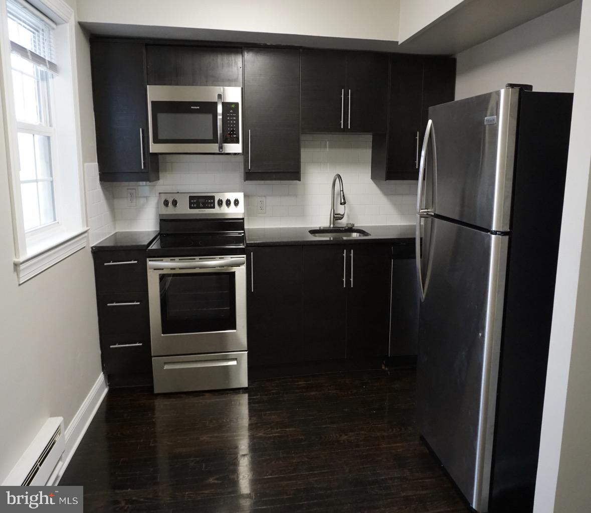 210 Trinity Avenue, Unit A1 Ambler, PA 19002 - Photo 7 of 8 a kitchen with a refrigerator stove and microwave