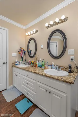 a bathroom with a granite countertop double vanity sink and a mirror