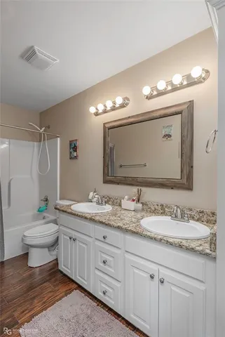 a bathroom with a granite countertop sink mirror and toilet
