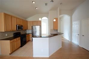 a large kitchen with a large counter top sink and stainless steel appliances
