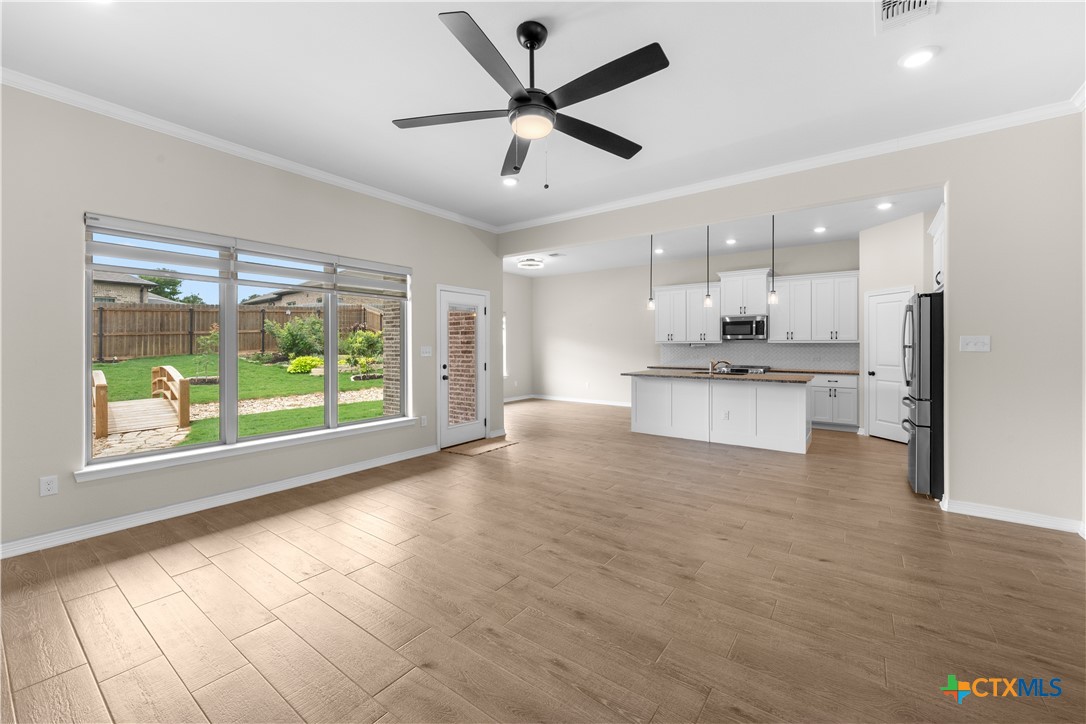 3405 Waggoner Drive Belton, TX 76513 - Photo 16 of 48 a large kitchen with stainless steel appliances granite countertop a stove a sink dishwasher and a large window with wooden floor