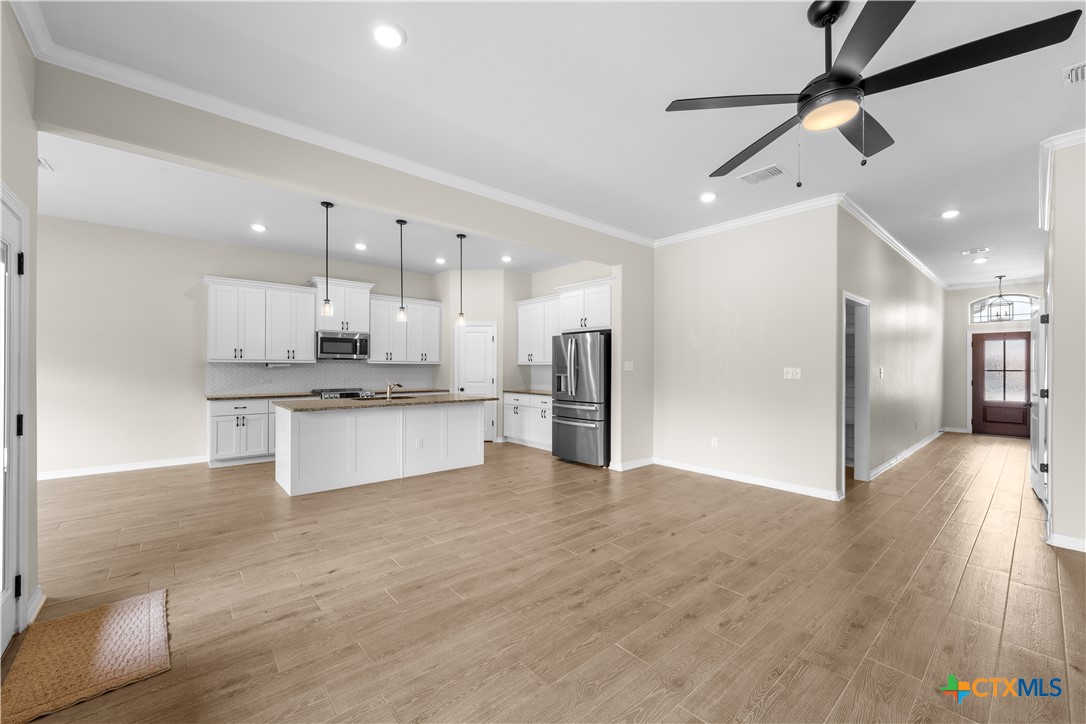 3405 Waggoner Drive Belton, TX 76513 - Photo 18 of 48 a large kitchen with white cabinets stainless steel appliances and a chandelier