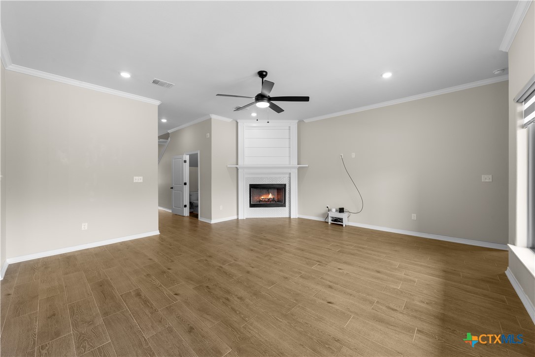 3405 Waggoner Drive Belton, TX 76513 - Photo 19 of 48 an empty room with a fireplace and a chandelier fan