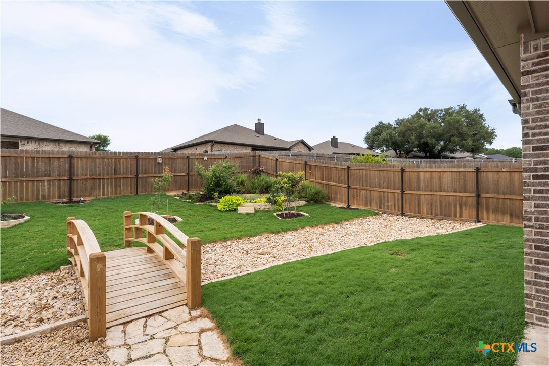 3405 Waggoner Drive Belton, TX 76513 - Photo 41 of 48 a view of a garden with a bench in front of a house