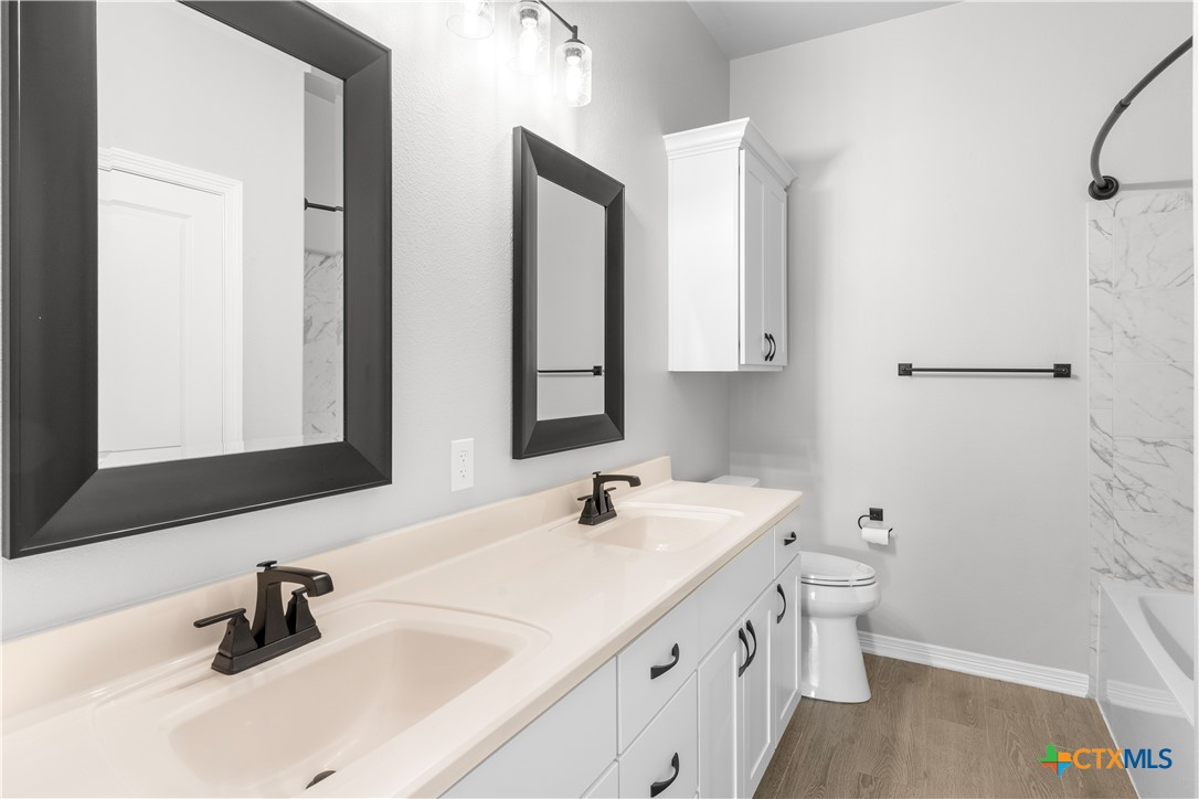 3405 Waggoner Drive Belton, TX 76513 - Photo 10 of 48 a bathroom with a double vanity sink a mirror and a bathtub