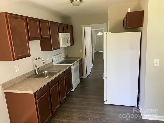 a kitchen with sink a refrigerator and a stove