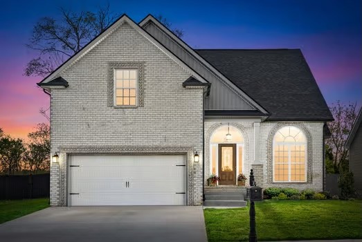 a view of a house with brick walls and a yard with plants