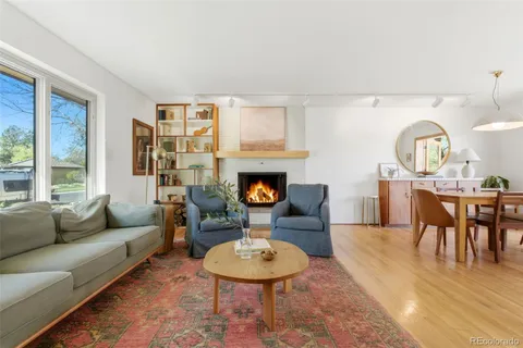 a living room with furniture a fireplace and kitchen view