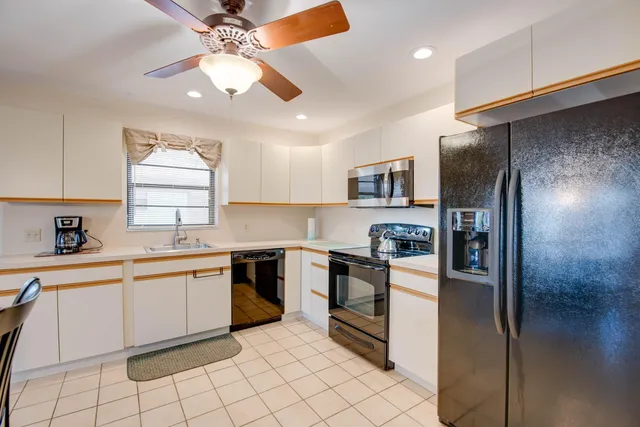 a kitchen with stainless steel appliances granite countertop a refrigerator and a sink