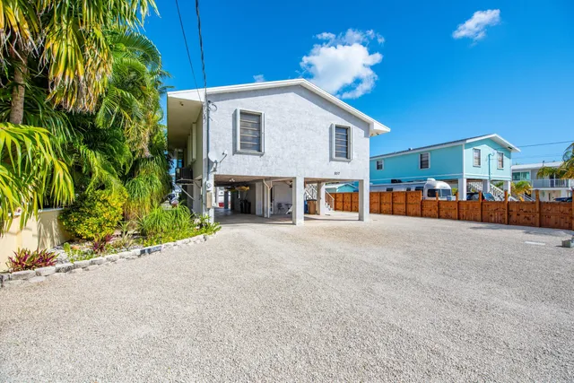 a view of a house with a yard and potted plants