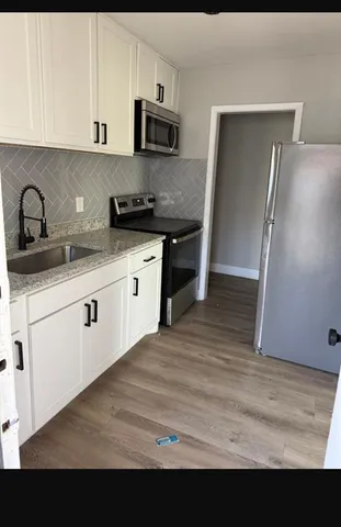 a kitchen with stainless steel appliances granite countertop a sink refrigerator and microwave